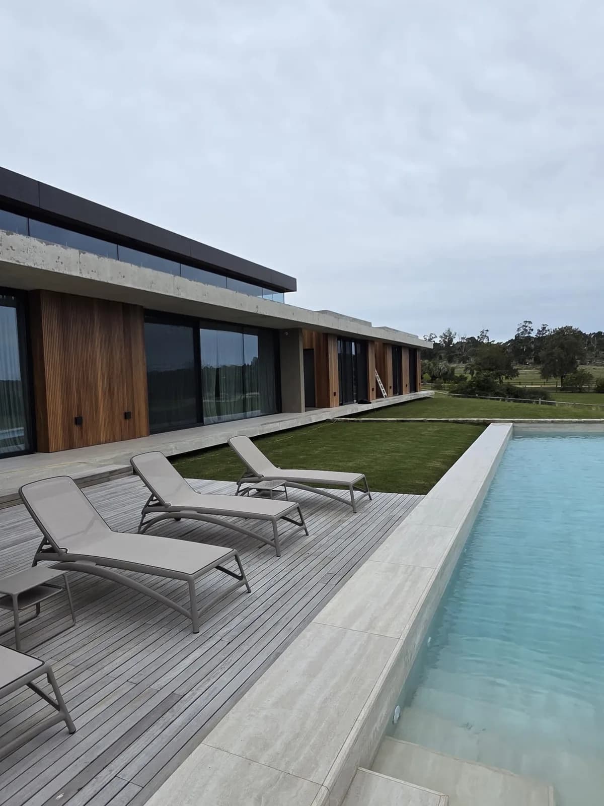 Solárium de madera tratada junto a piscina exterior